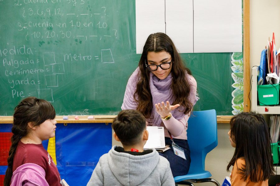 an elementary school teacher working with a student